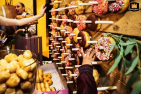   At Garré Vineyard in Livermore, California, lively wedding reception details showing hands reaching for donuts hanging on pegs on a board.